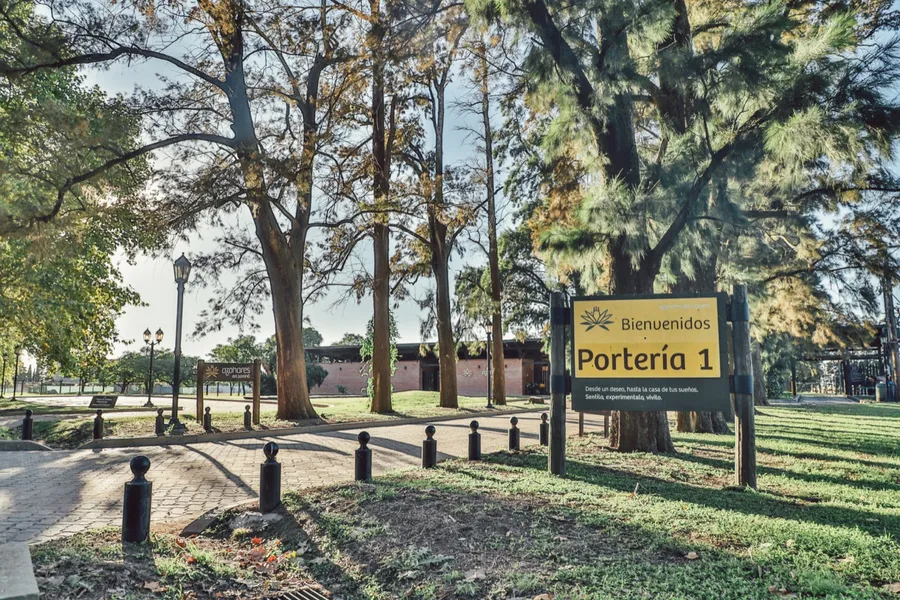 Acceso principal del barrio con cartel de bienvenida